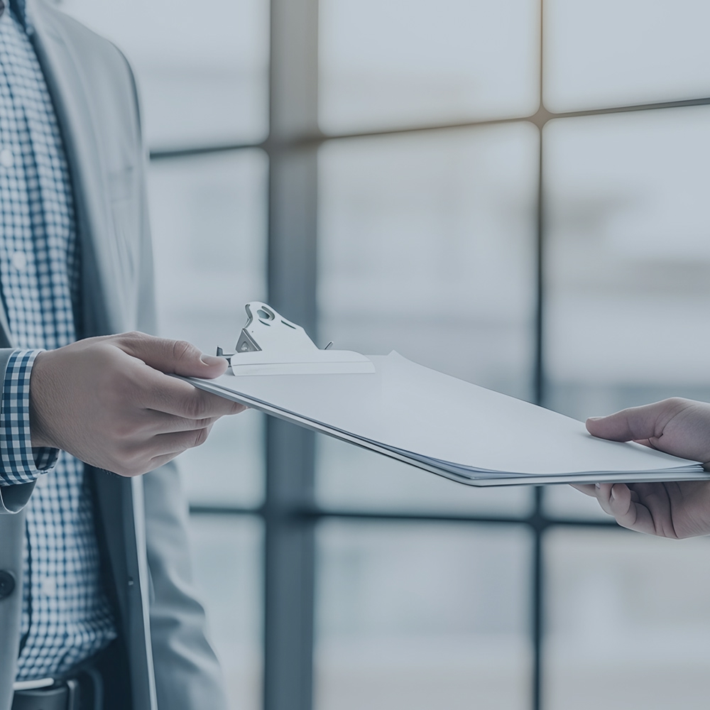 ビジネスシーンにおいて、書類を丁寧に手渡している二人の手元